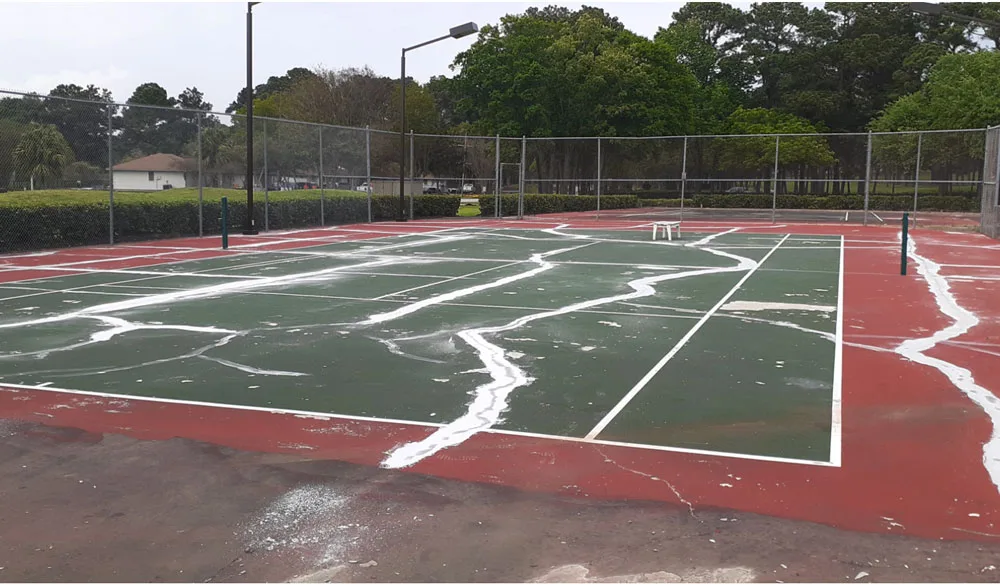 Before: Worn and faded tennis court surface in Houston TX